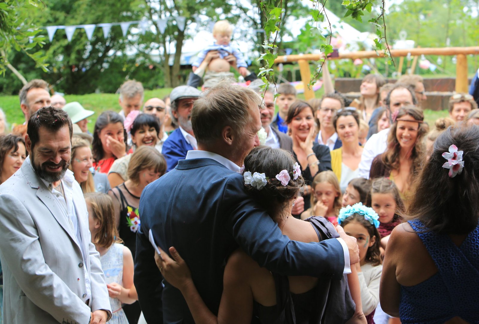 A couple embracing surrounded by their wedding guests