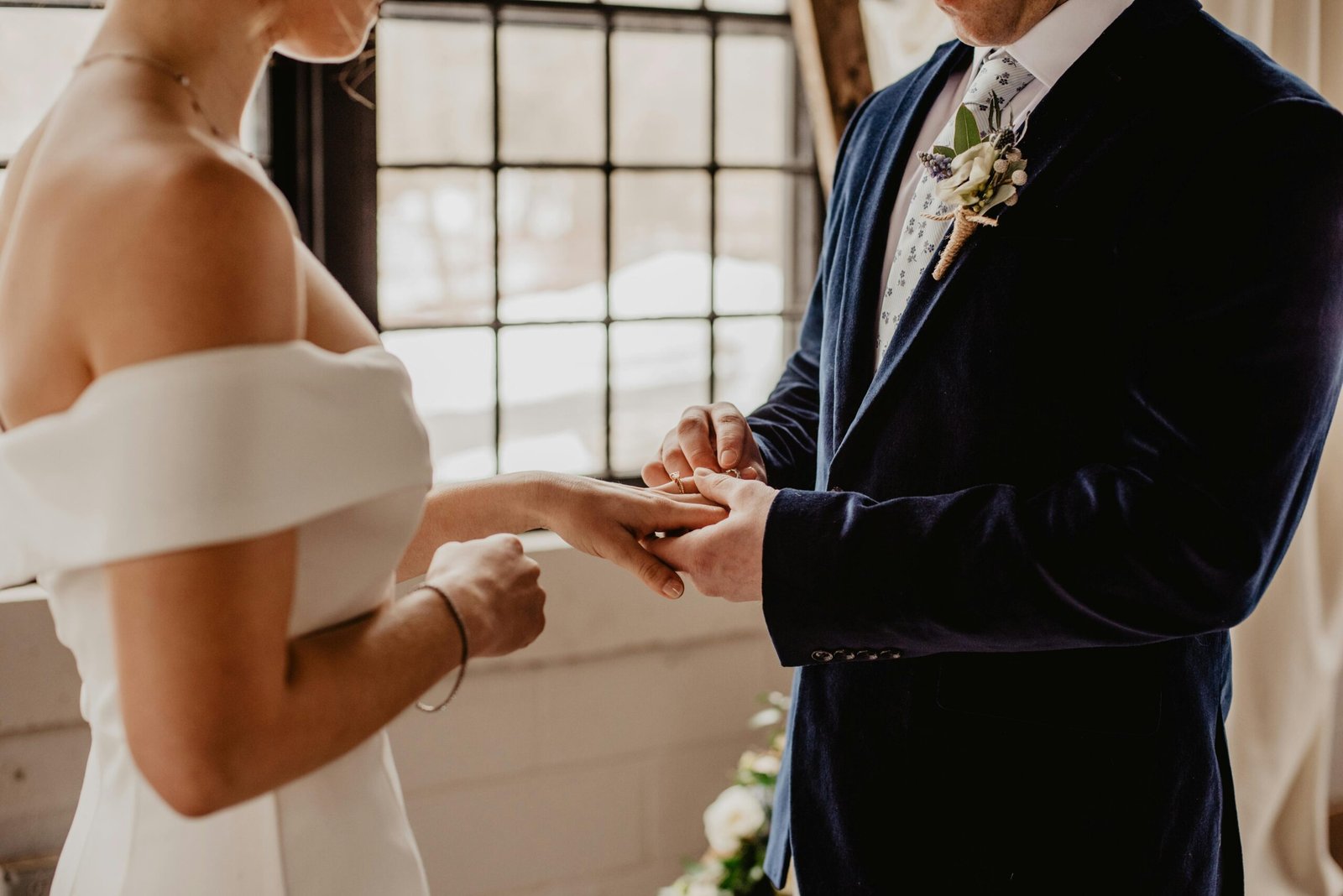 A couple holding hands, rings visible