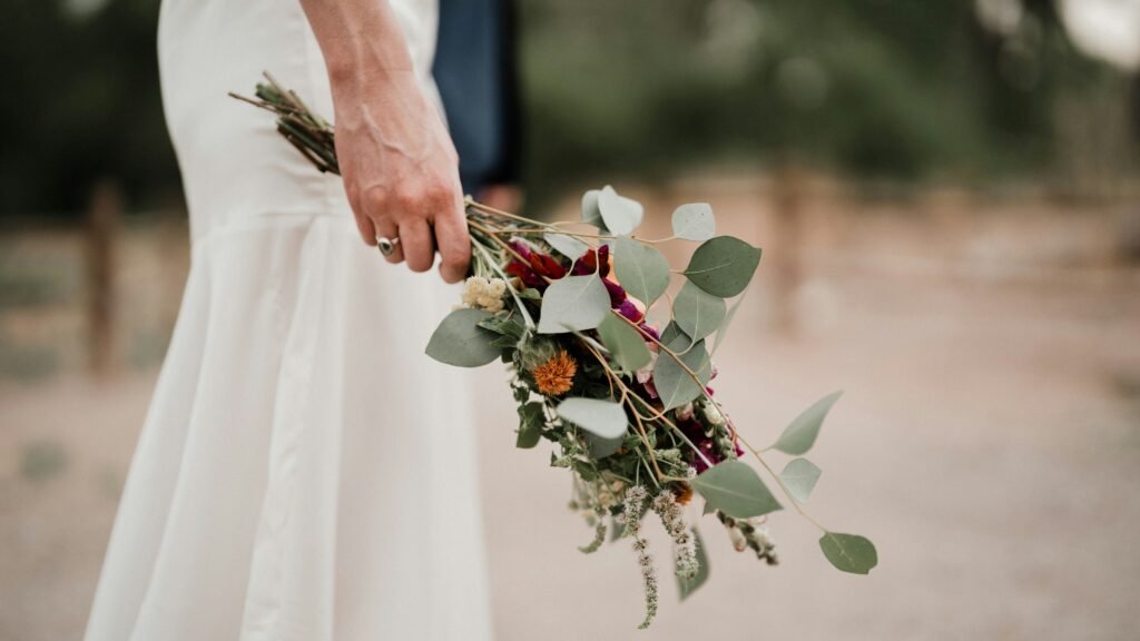 A bride holding an elegant bouquet of flowers - www.iamacelebrant.uk